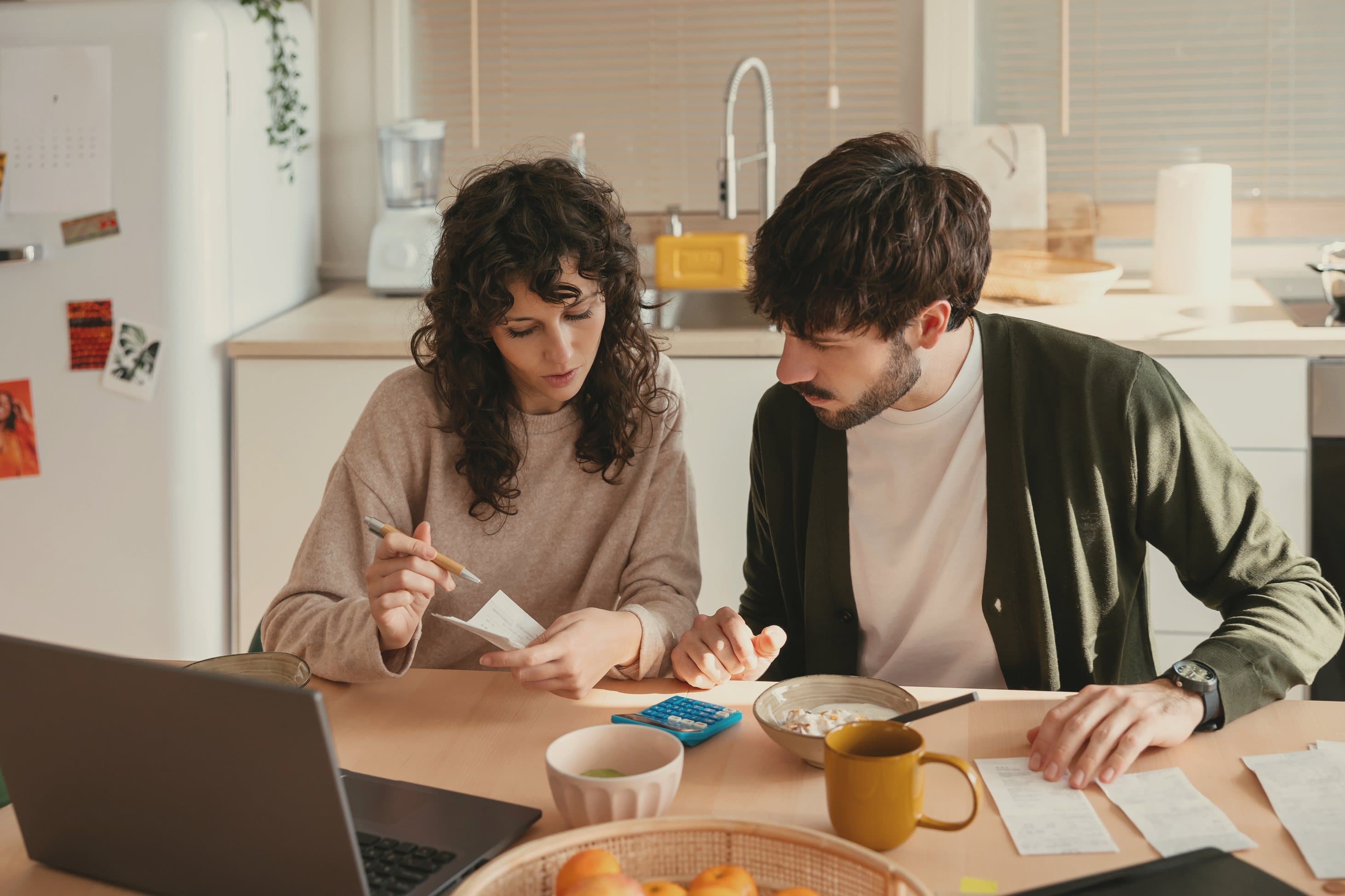 A couple reviewing their mortgage numbers and documents at the kitchen table