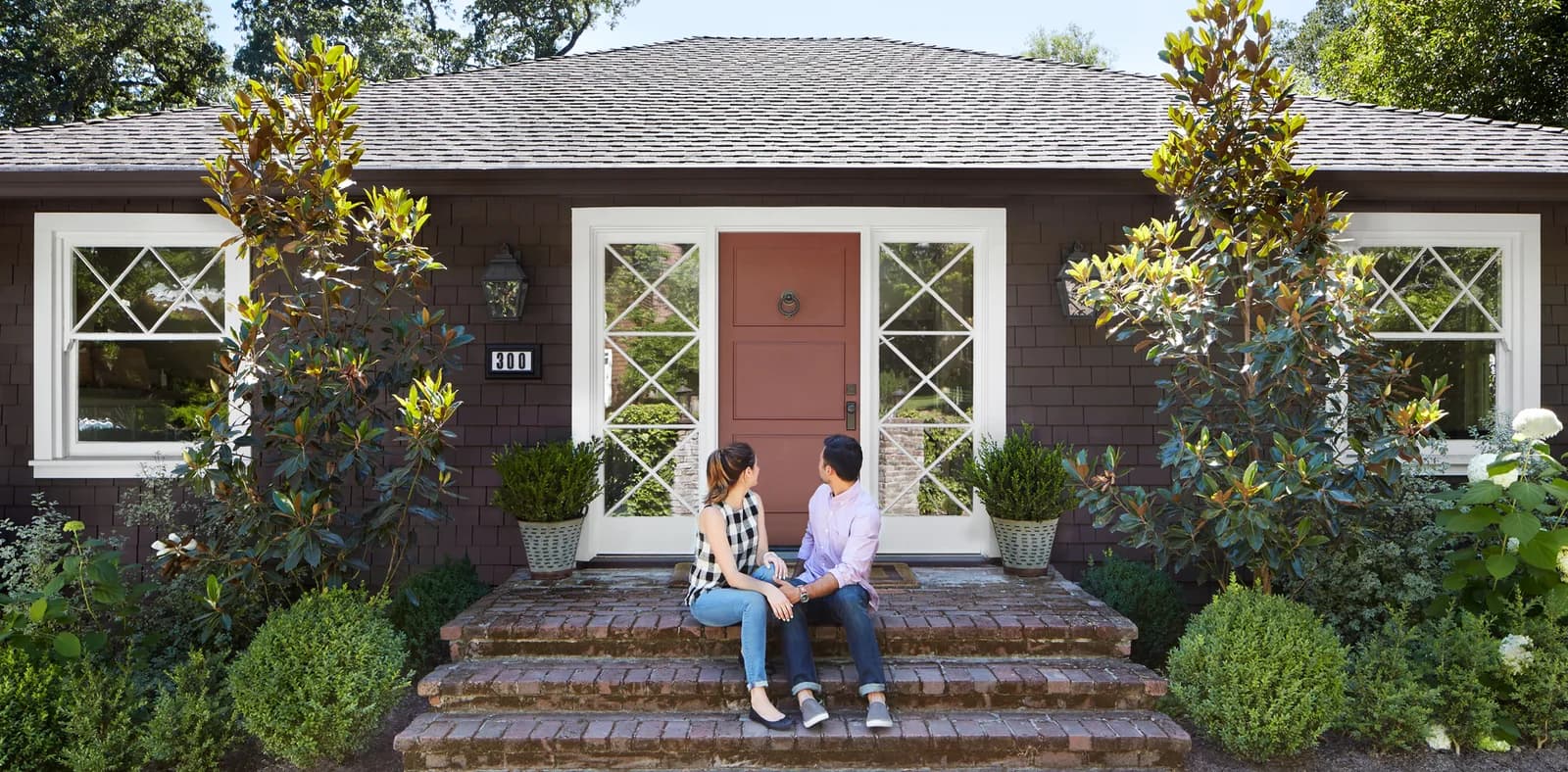 A couple sitting together on the front steps of a home