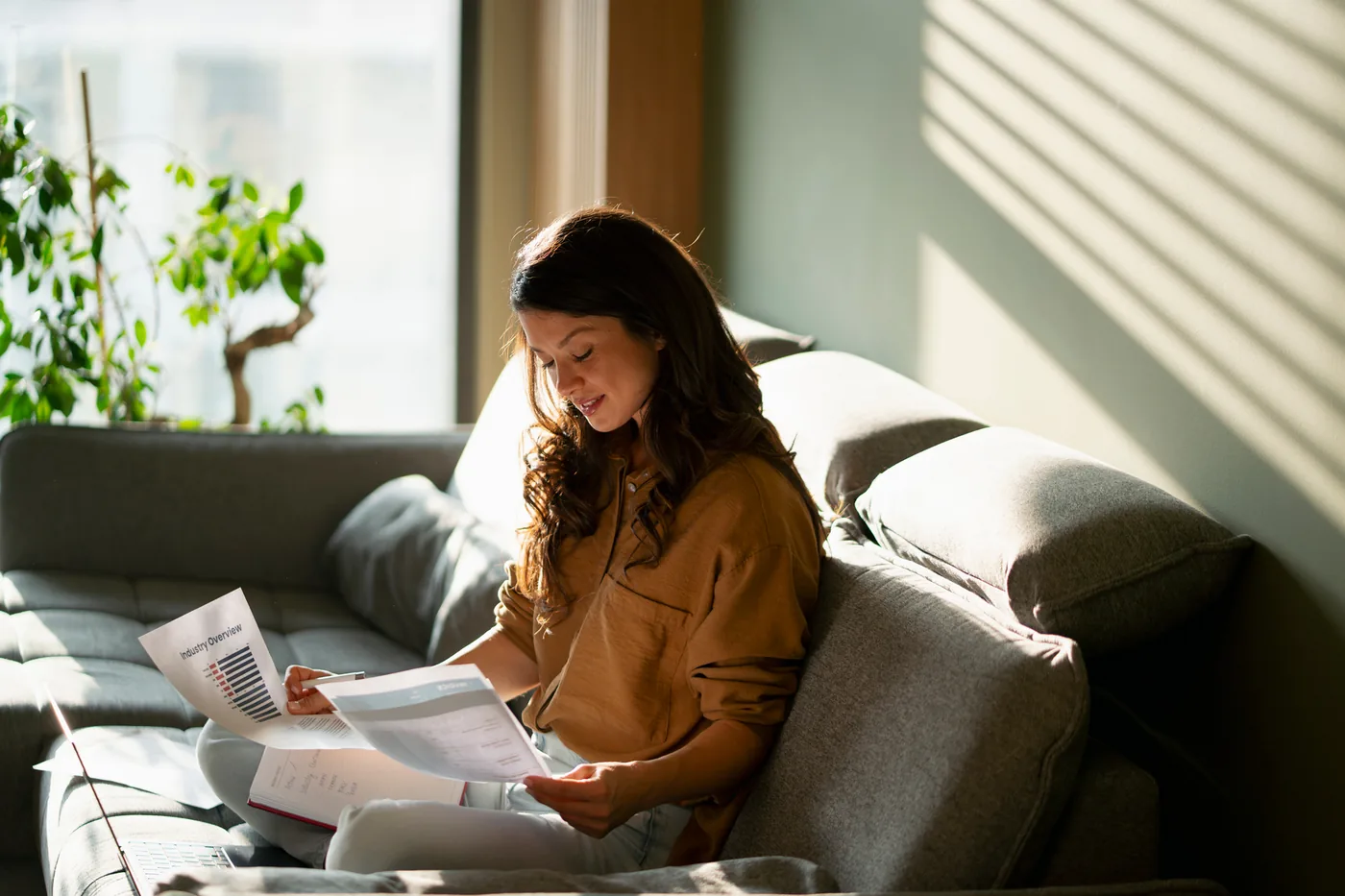 Someone sitting at home comparing two printed loan documents side by side
