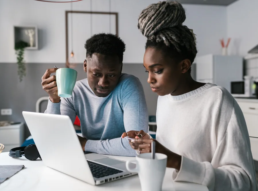 A couple reviewing their finances on a laptop at home